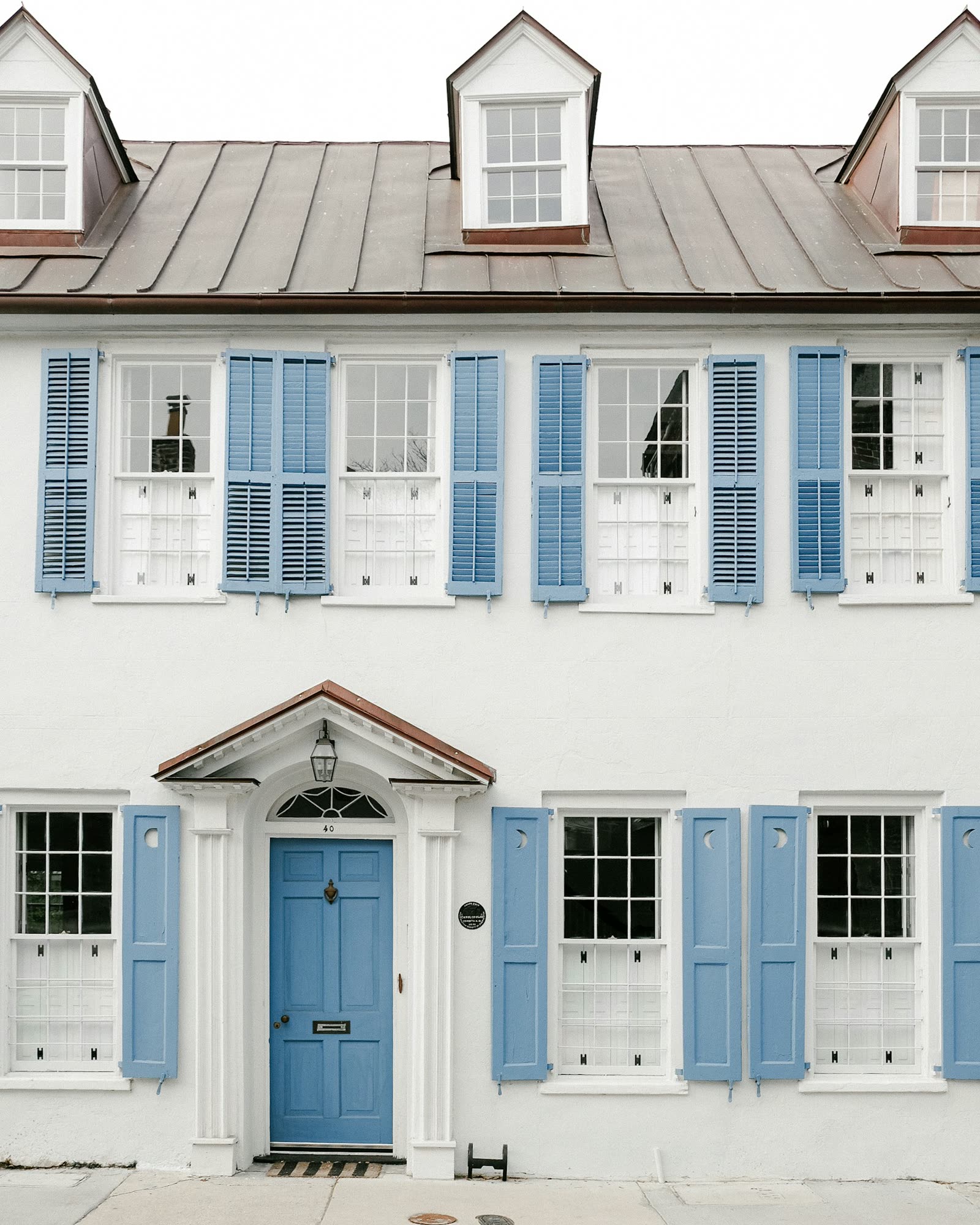 Façade blanche aux volets peints